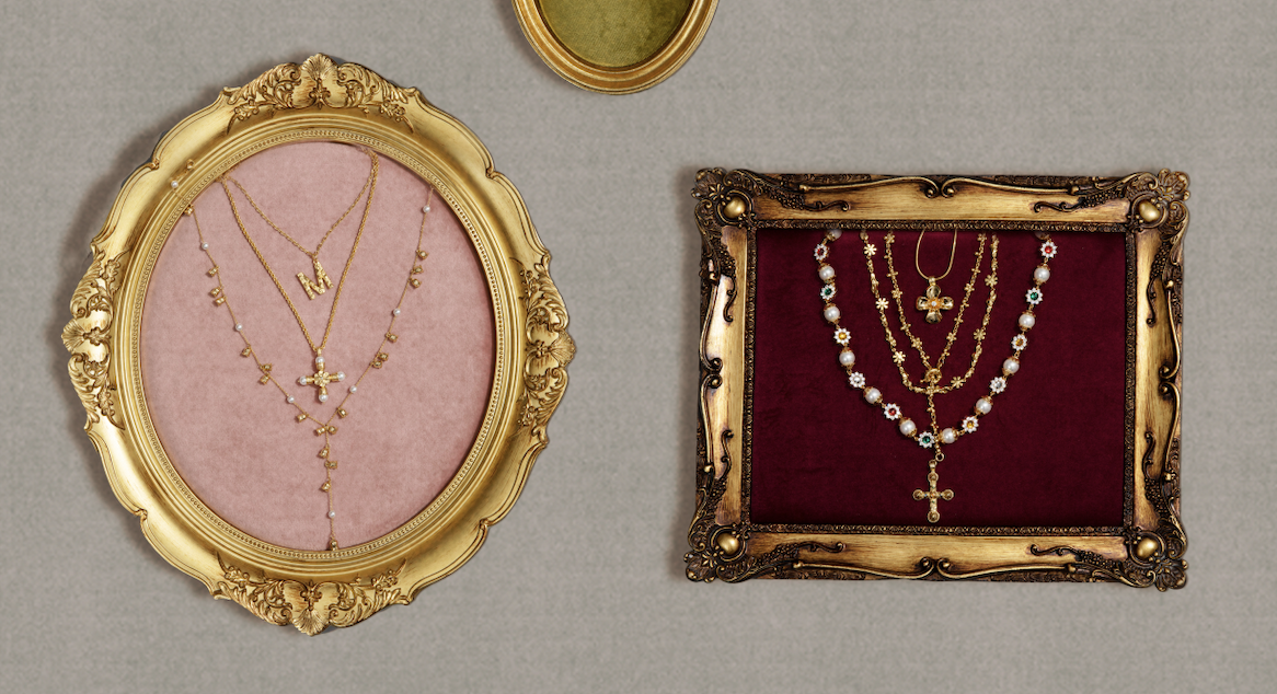 Vintage-inspired styling of multiple layered gold pearl and cross necklaces beautifully displayed inside ornate antique picture frames.