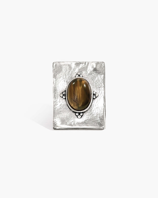 Silver ring with oval tiger's eye gemstone and textured band, part of En Route Jewelry's collection.